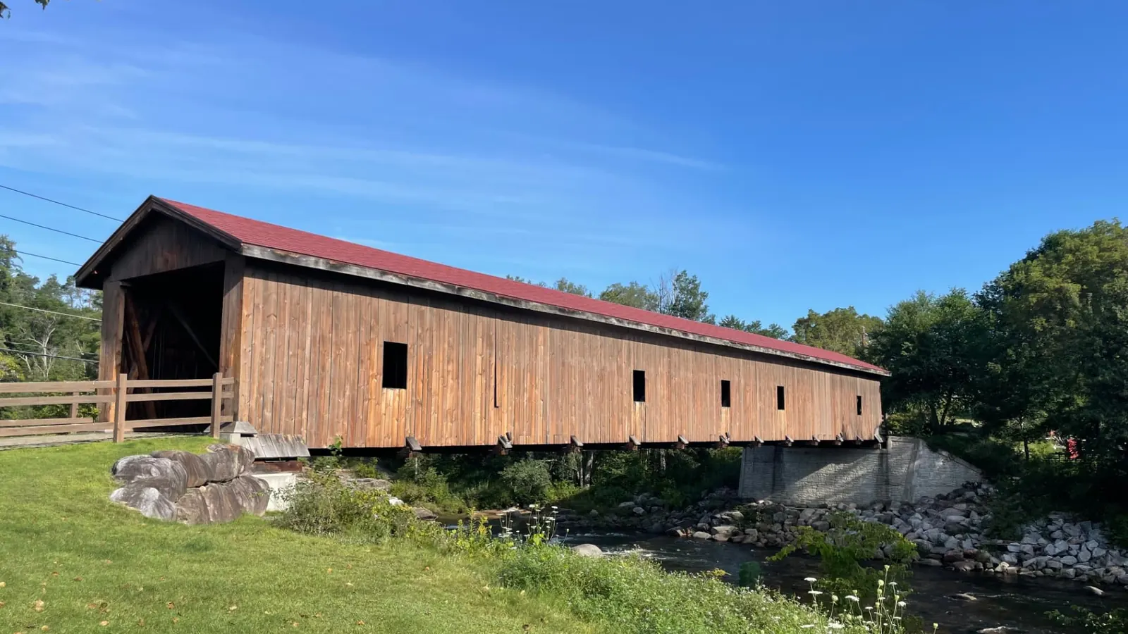 The Jay covered bridge, its weathered board siding and red roof spanning the AuSable River in the center of the hamlet